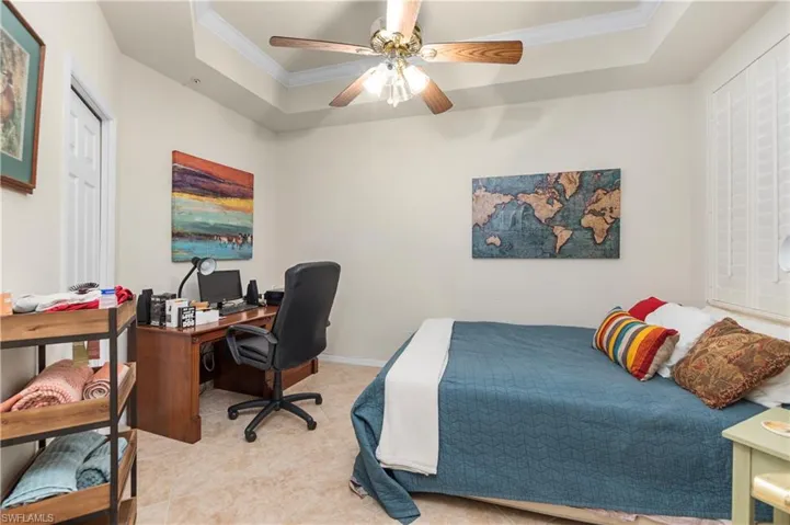 Bedroom with a raised ceiling, a ceiling fan, and ornamental molding