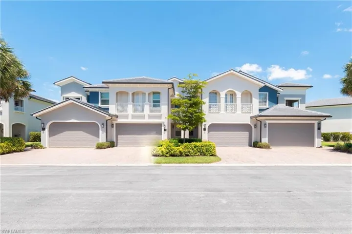 View of front of house with stucco siding, a garage, a balcony, and decorative driveway