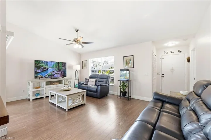 Living room featuring wood finished floors, ceiling fan, and lofted ceiling