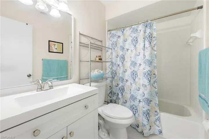 Bathroom featuring vanity and shower / tub combo with curtain