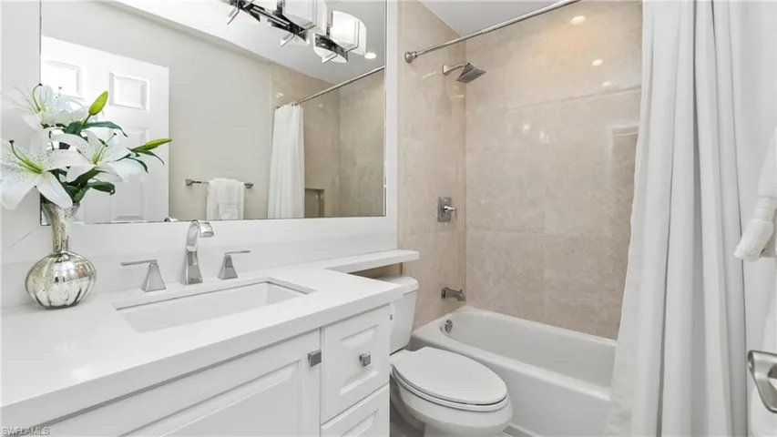 Bathroom featuring shower / tub combo with curtain and vanity