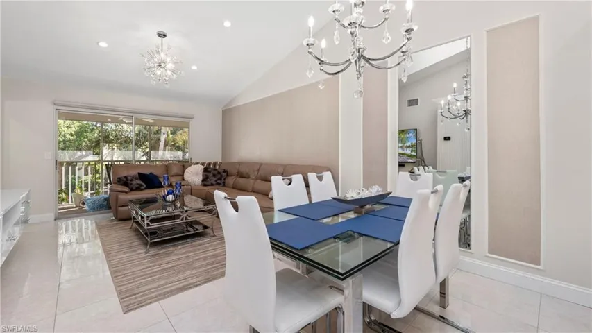 Dining space with a chandelier, light tile patterned flooring, recessed lighting, and high vaulted ceiling