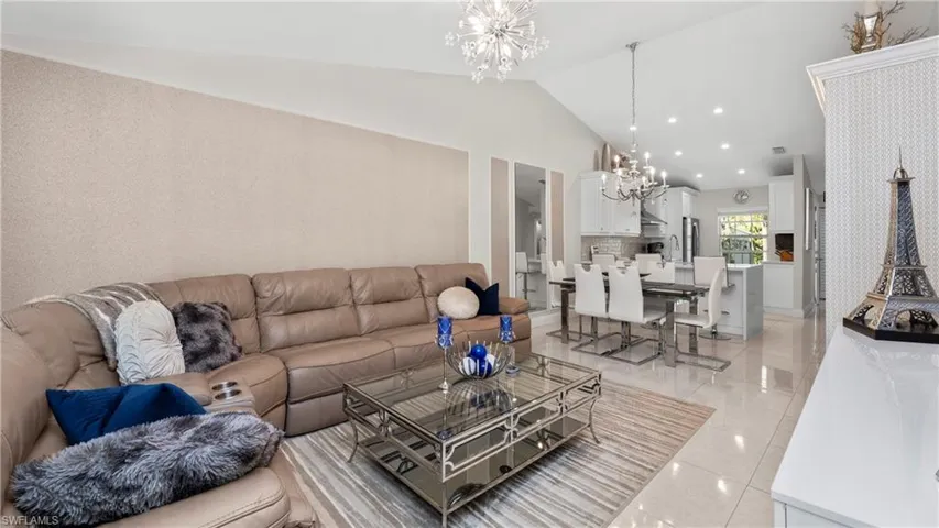 Living area featuring a chandelier, lofted ceiling, recessed lighting, and light tile patterned floors