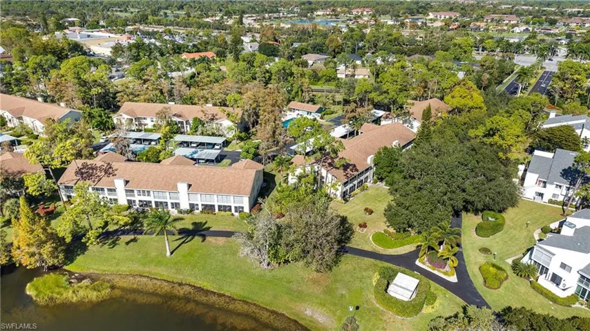 Aerial view of property and surrounding area with a large body of water and nearby suburban area