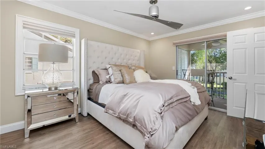 Bedroom with access to exterior, wood finished floors, multiple windows, ornamental molding, and a ceiling fan