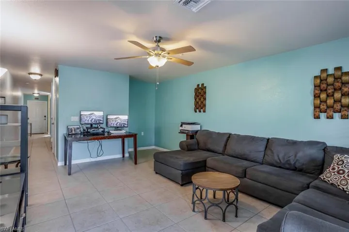 Living room featuring ceiling fan and light tile patterned flooring