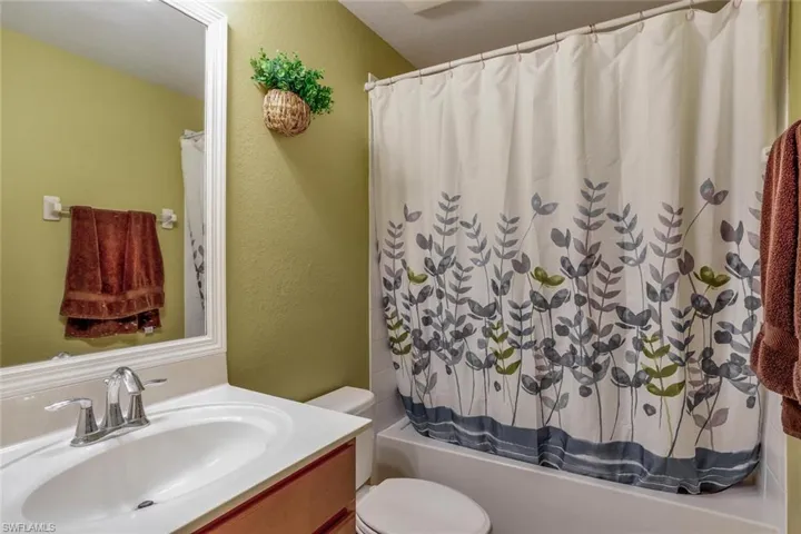 Full bathroom featuring vanity, toilet, and shower / tub combo with curtain