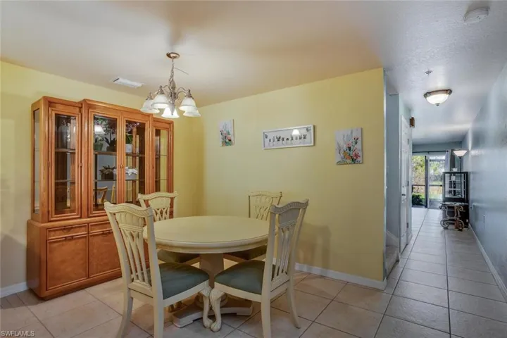Dining area with light tile patterned flooring and a chandelier