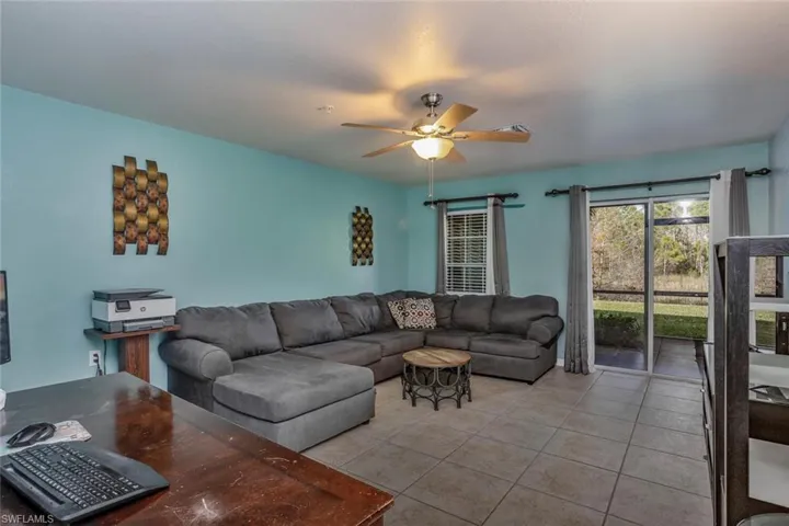 Tiled living room featuring ceiling fan