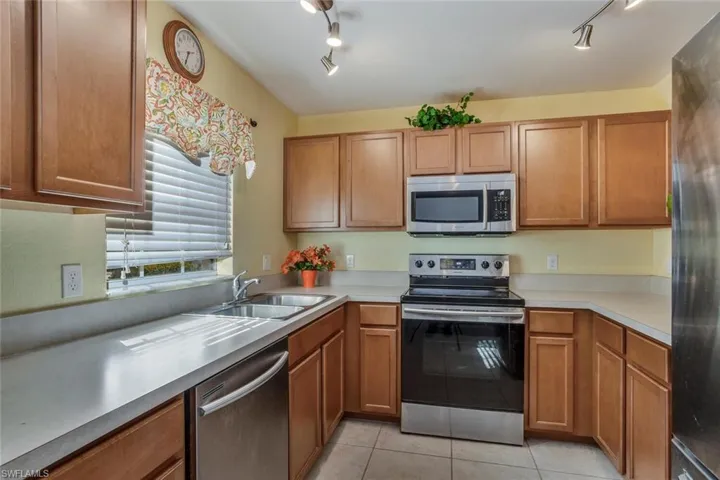 Kitchen featuring sink, light tile patterned floors, and appliances with stainless steel finishes
