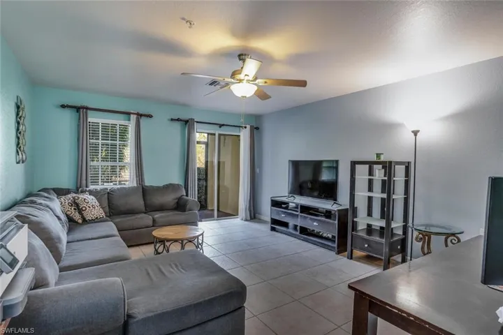 Living room featuring tile patterned floors and ceiling fan
