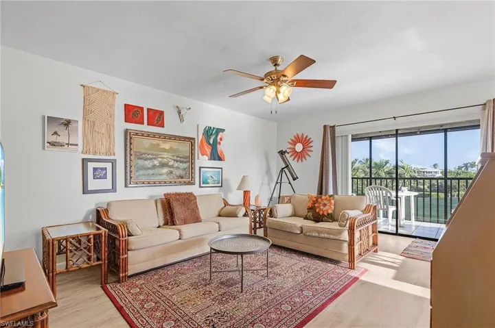 Living room with newer flooring and glass sliders to lania