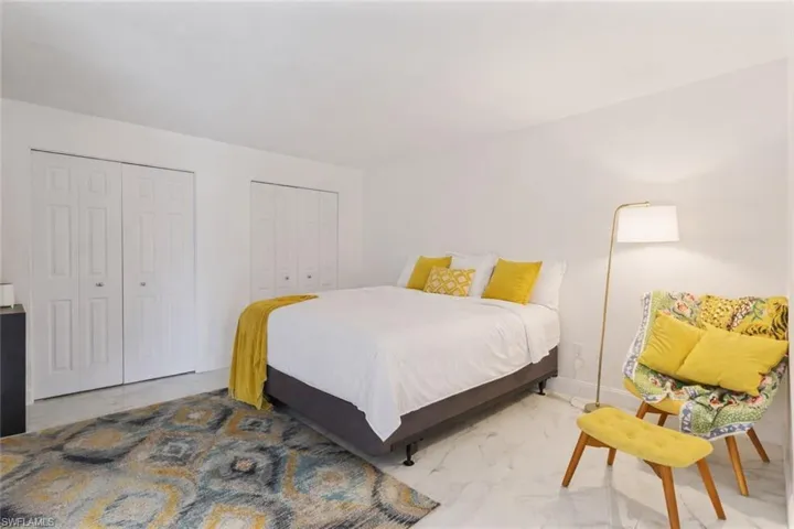 Bedroom with two closets and light marble finish flooring