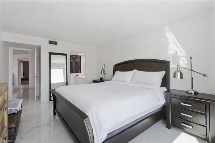 Bedroom featuring light marble finish floors and ensuite bathroom