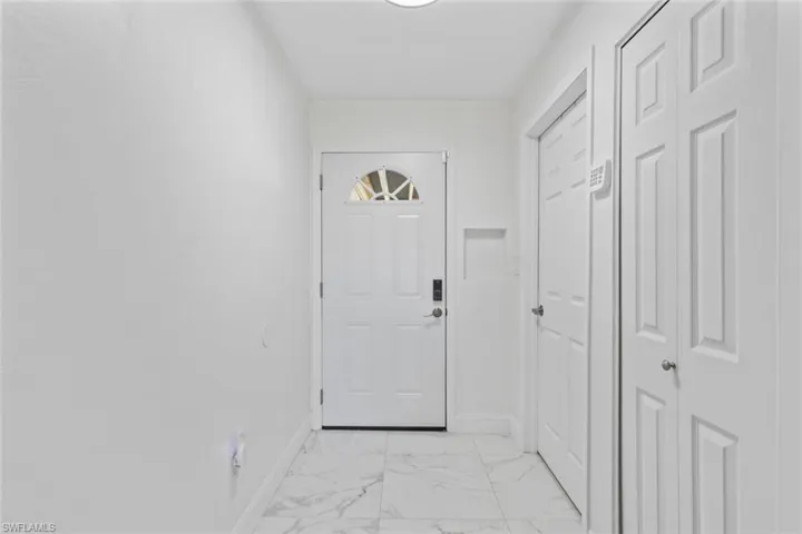 Entryway featuring marble finish floors and baseboards