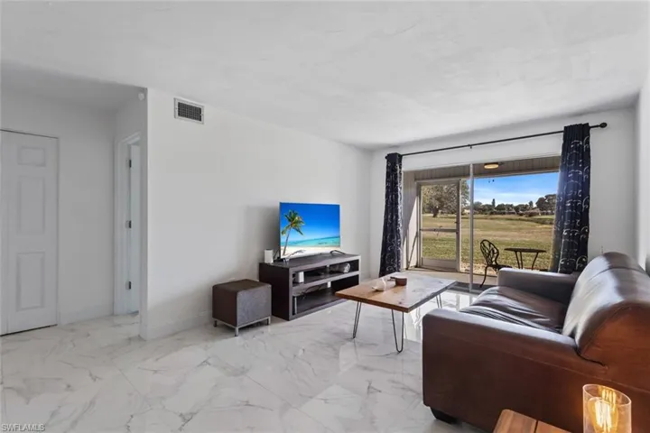 Living area featuring light marble finish floors and baseboards