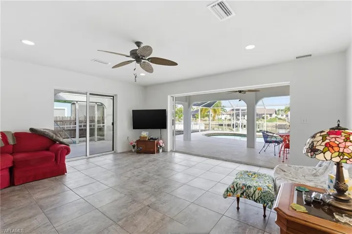 Tiled living area with a sunroom and recessed lighting
