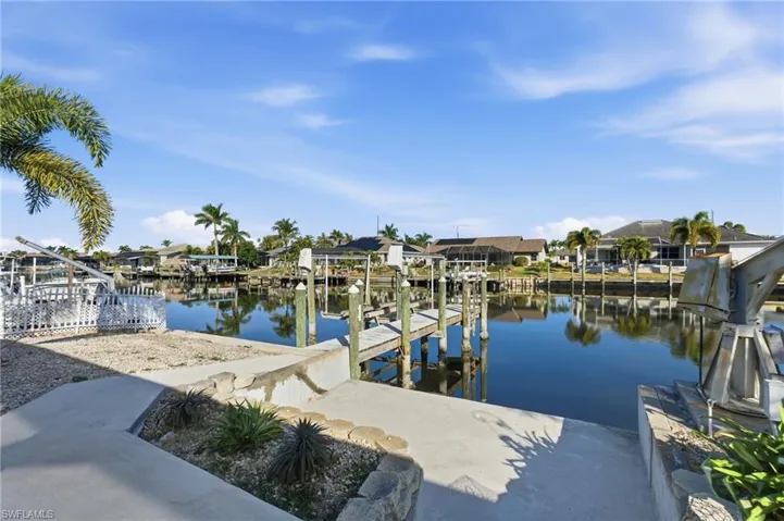 Dock featuring boat lift, a water view, and a residential view