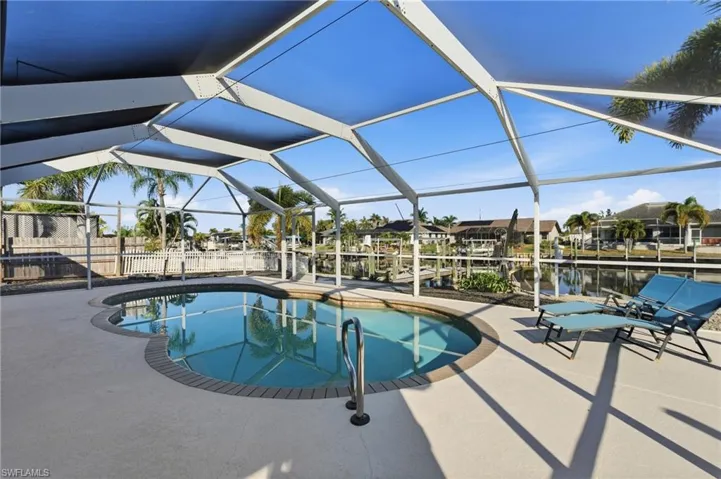 Swimming pool with glass enclosure, a sunroom, a patio, and a residential view