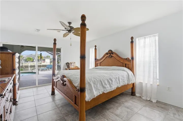 Bedroom featuring access to exterior, multiple windows, and light tile patterned floors