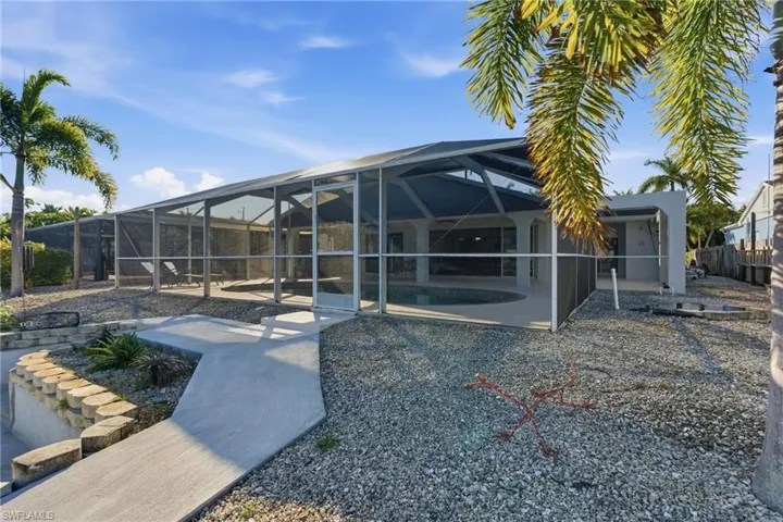 Rear view of house with a lanai, a sunroom, an outdoor pool, and a patio
