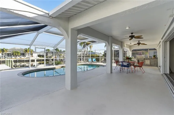 Swimming pool with a patio area, a sunroom, glass enclosure, and outdoor dining area