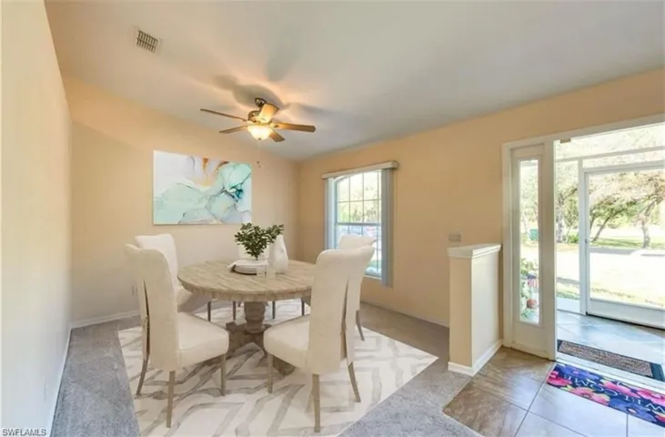 Carpeted dining room featuring a ceiling fan and lofted ceiling