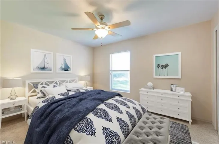 Bedroom with light colored carpet and a ceiling fan