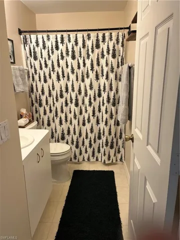 Bathroom with tile patterned floors, vanity, and a shower with curtain