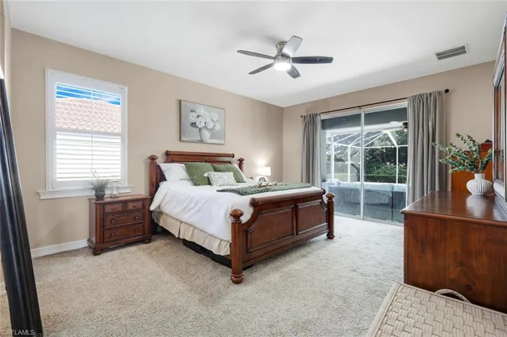 Carpeted flooring, ceiling fan with integrated lighting, glass sliding doors, window with horizontal blinds