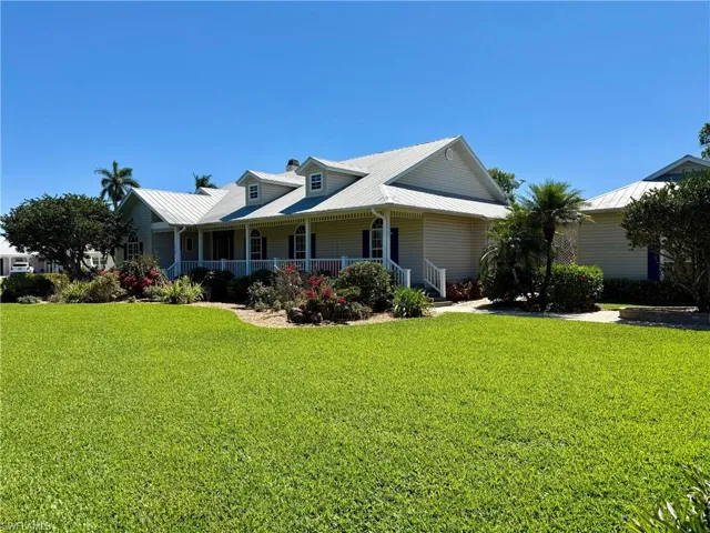 View of front of property with covered porch and a front yard