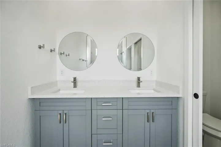 Bathroom featuring double vanity and toilet