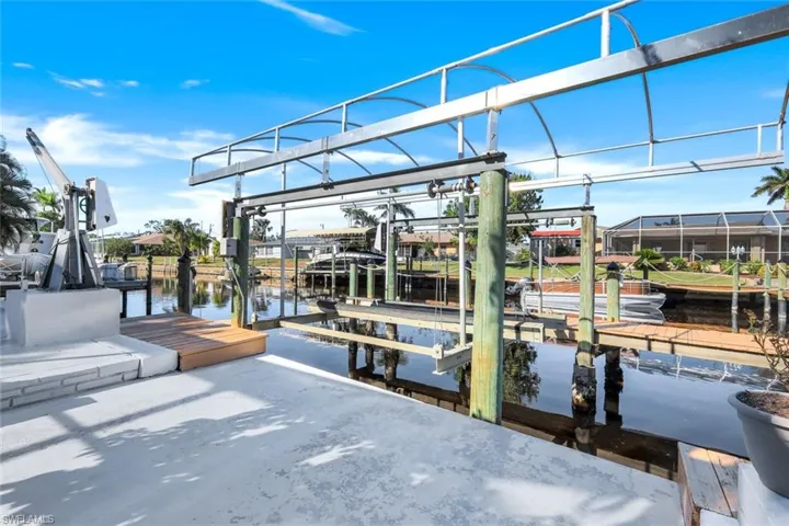 View of dock and lift  featuring a water view