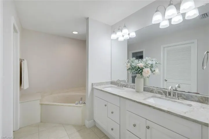 Bathroom featuring tile patterned floors, a oversized tub, and vanity