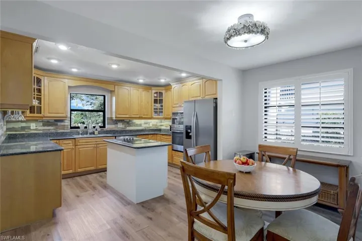 Kitchen featuring ss appliances, double oven, decorative backsplash, a kitchen island, and sink