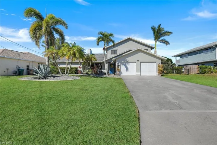 View of front of house with a spacious 2 car garage and a front lawn