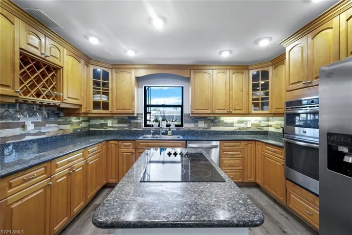 Kitchen featuring a granite center island, sink, and stainless steel appliances