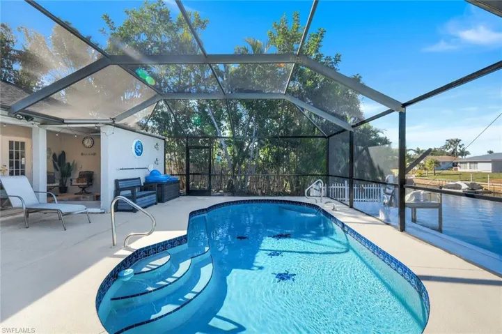 View of HEATED pool with a lanai and a patio