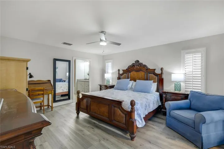 Bedroom with connected bathroom, ceiling fan, and French doors to hot tub & pool