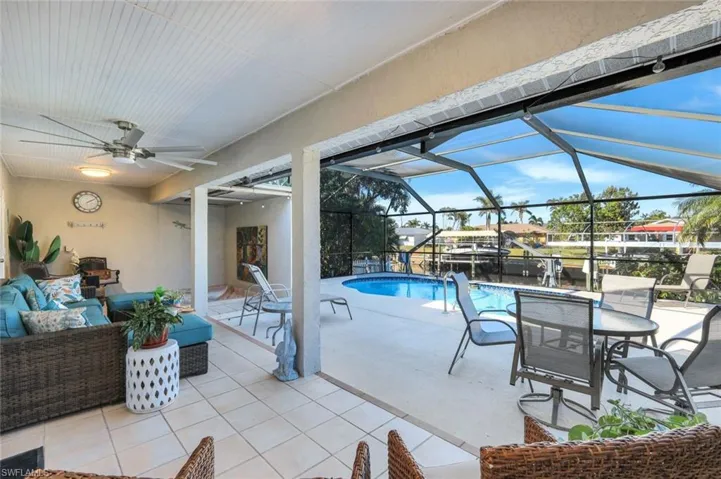 View of swimming pool featuring outdoor lounge area, a patio, ceiling fan, and a lanai