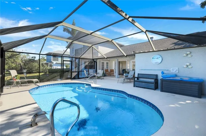 View of swimming pool with fountain - featuring french doors, a patio, a hot tub, and a lanai