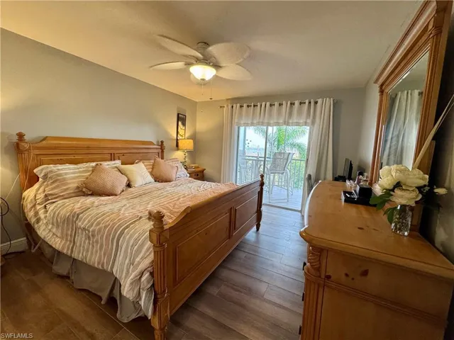 Bedroom featuring ceiling fan, dark wood-type flooring, and access to exterior