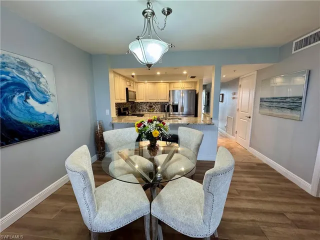 Dining space with dark wood-type flooring and sink