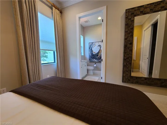 Unfurnished bedroom with crown molding and connected bathroom