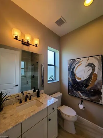 Bathroom featuring walk in shower, vanity, toilet, and hardwood / wood-style flooring