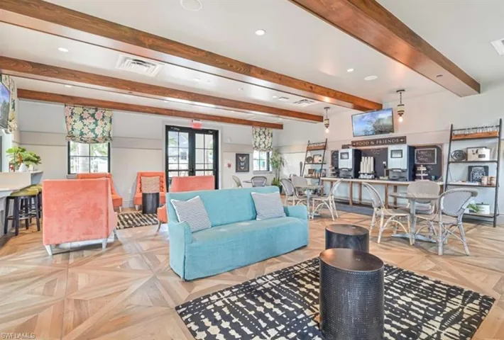 Living room with light parquet floors, french doors, and beamed ceiling