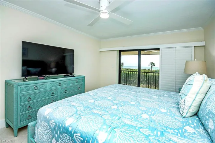 Bedroom featuring access to exterior, crown molding, ceiling fan, and tile patterned floors