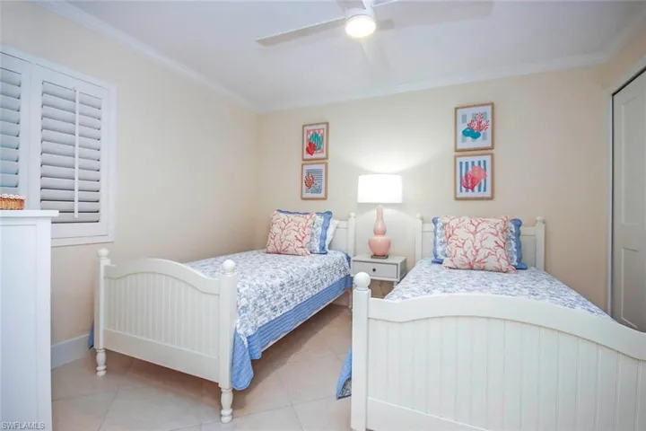 Bedroom featuring ornamental molding, tile patterned floors, and ceiling fan
