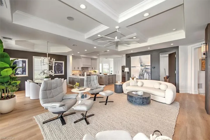 Great room with engineered oak flooring, crown molding, coffered ceilings, recessed lighting and ceiling fans