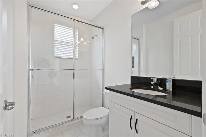 Full bathroom featuring vanity, a shower stall, and tile patterned flooring